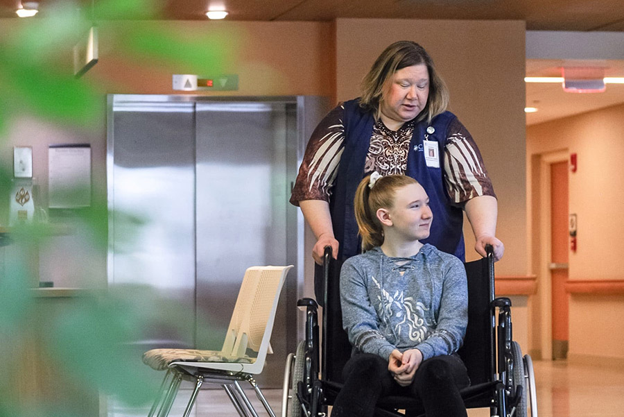 A girl being pushed in a wheelchair