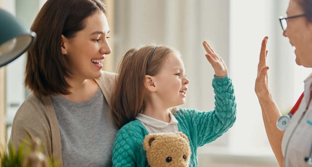 A young girl giving a doctor a high five