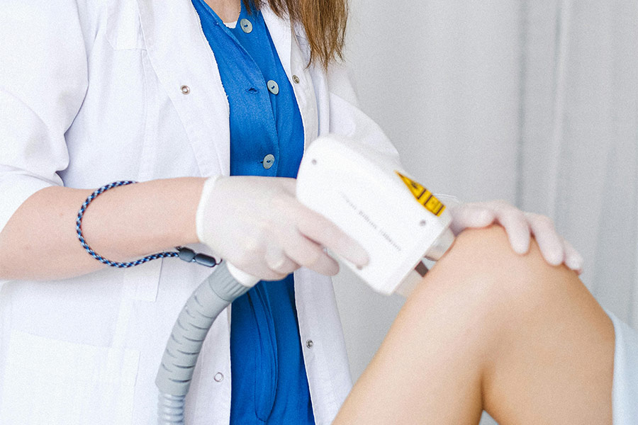 Nurse examining a patient's knee.