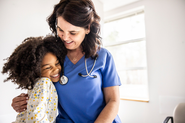Nurse hugging young patient