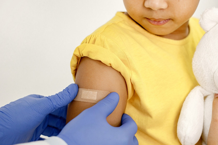 Nurse putting a bandaid on young child's arm