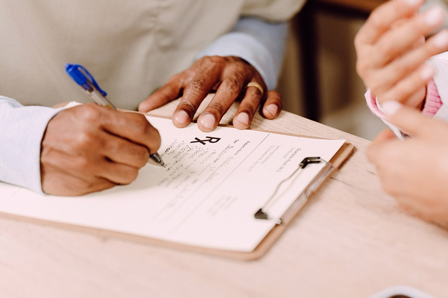 Healthcare provider writing on clipboard