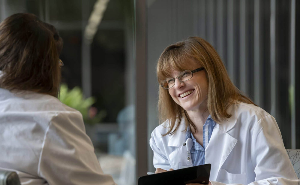 A healthcare provider conversing with another individual